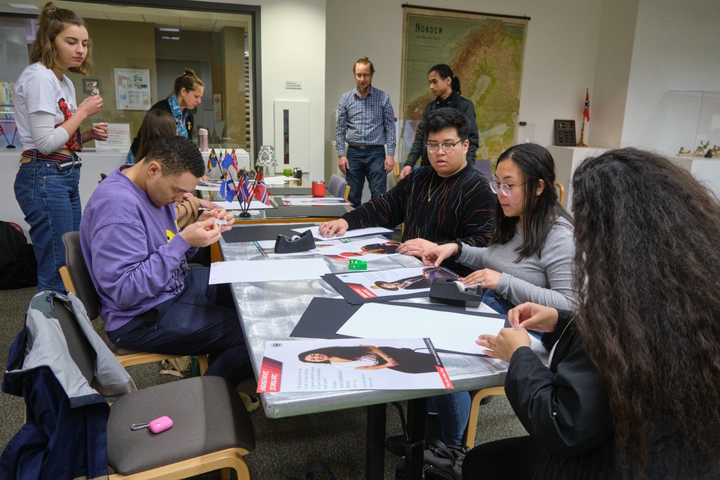 A poster exhibition designed and installed by Native American & Indigenous Studies students Fall 2019 - students working at a table