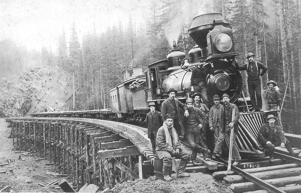 np-workers-3171x2027-1024x655 Workers standing next to a steam train engine.