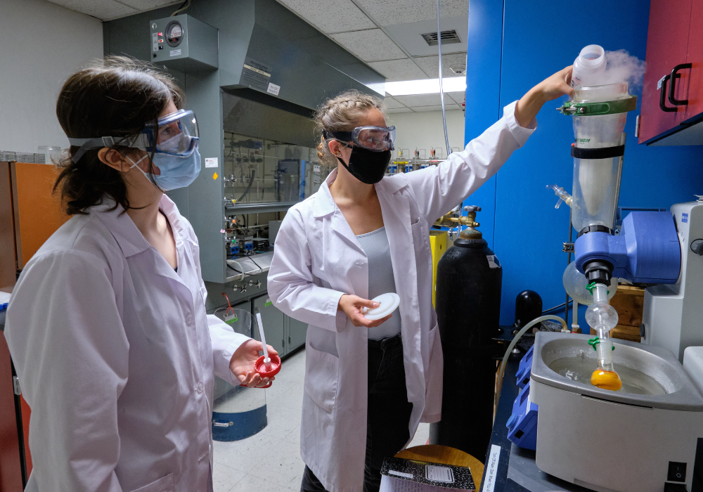 Two students are conducting chem research in a chem lab in Rieke.