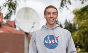 plu student wearing a NASA shirt smiles into the camera.
