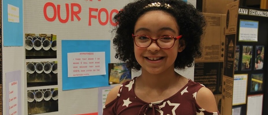 Science Fair Student in front of her display.JPG