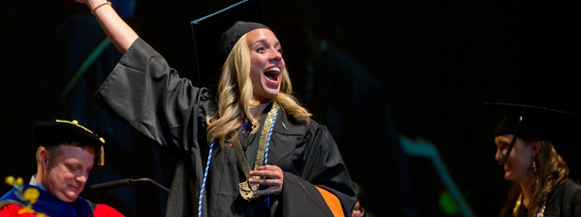 Graduate waving on stage