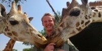 Nev Granum feeding a couple giraffes
