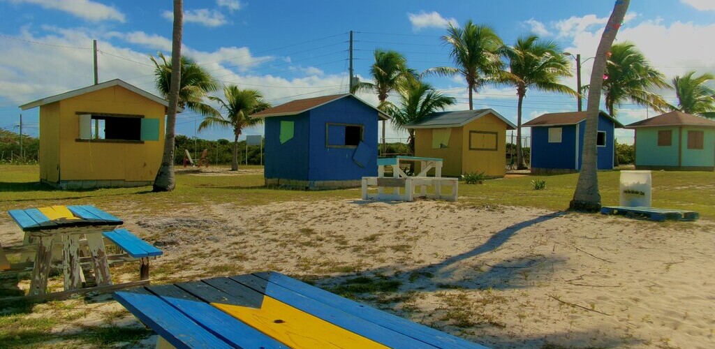 Bahama beach scene with picnic tables and beach cabanas