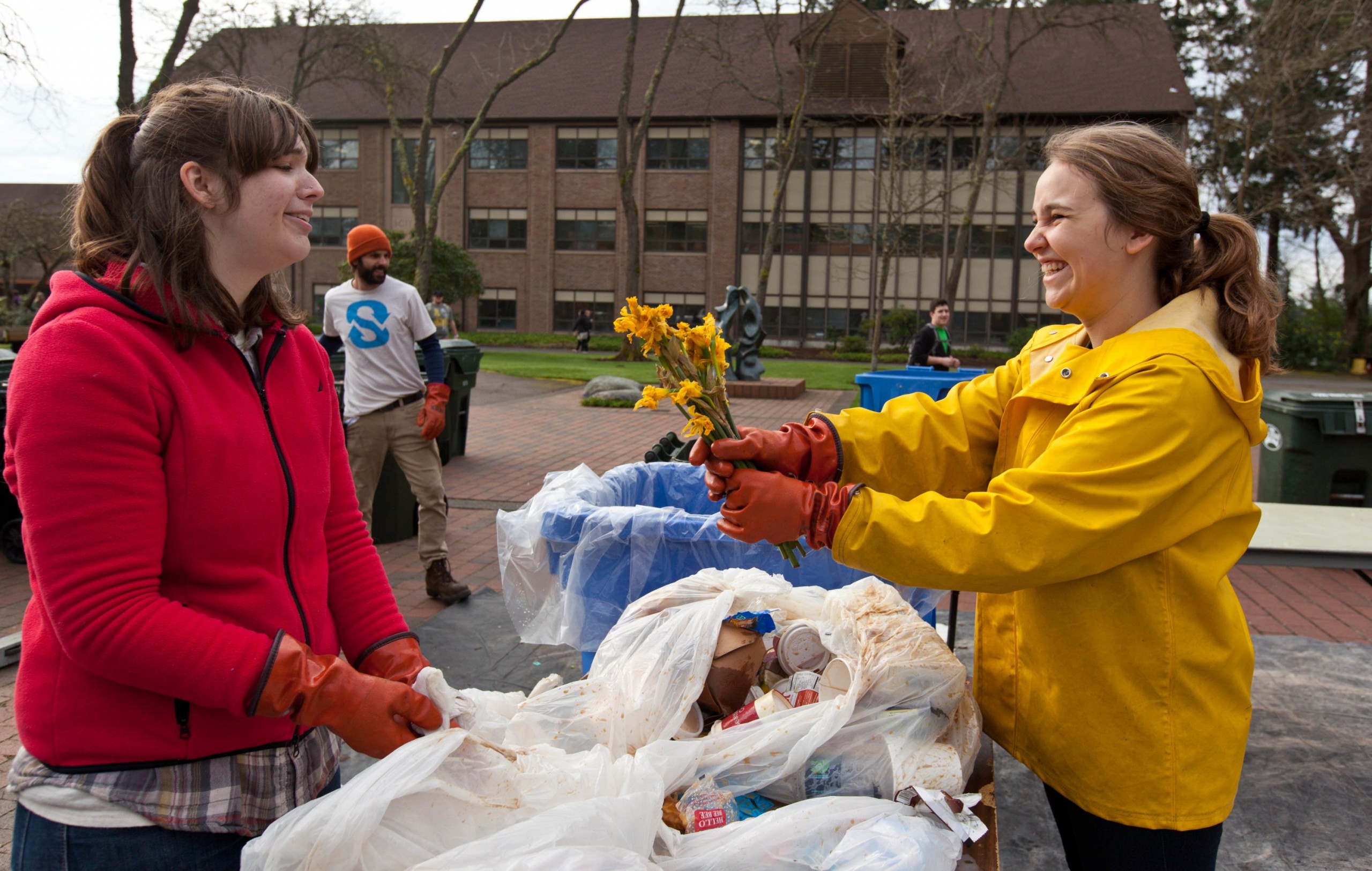 Savannah Phalan '15, right, and Sarah Wheeler 15, work on a table of trash during Garbology on Red Square, where grash from different locations is sorted to determine how much is recycleable or compostable at PLU on Tuesday, March 17, 2015. (Photo: John Froschauer/PLU)