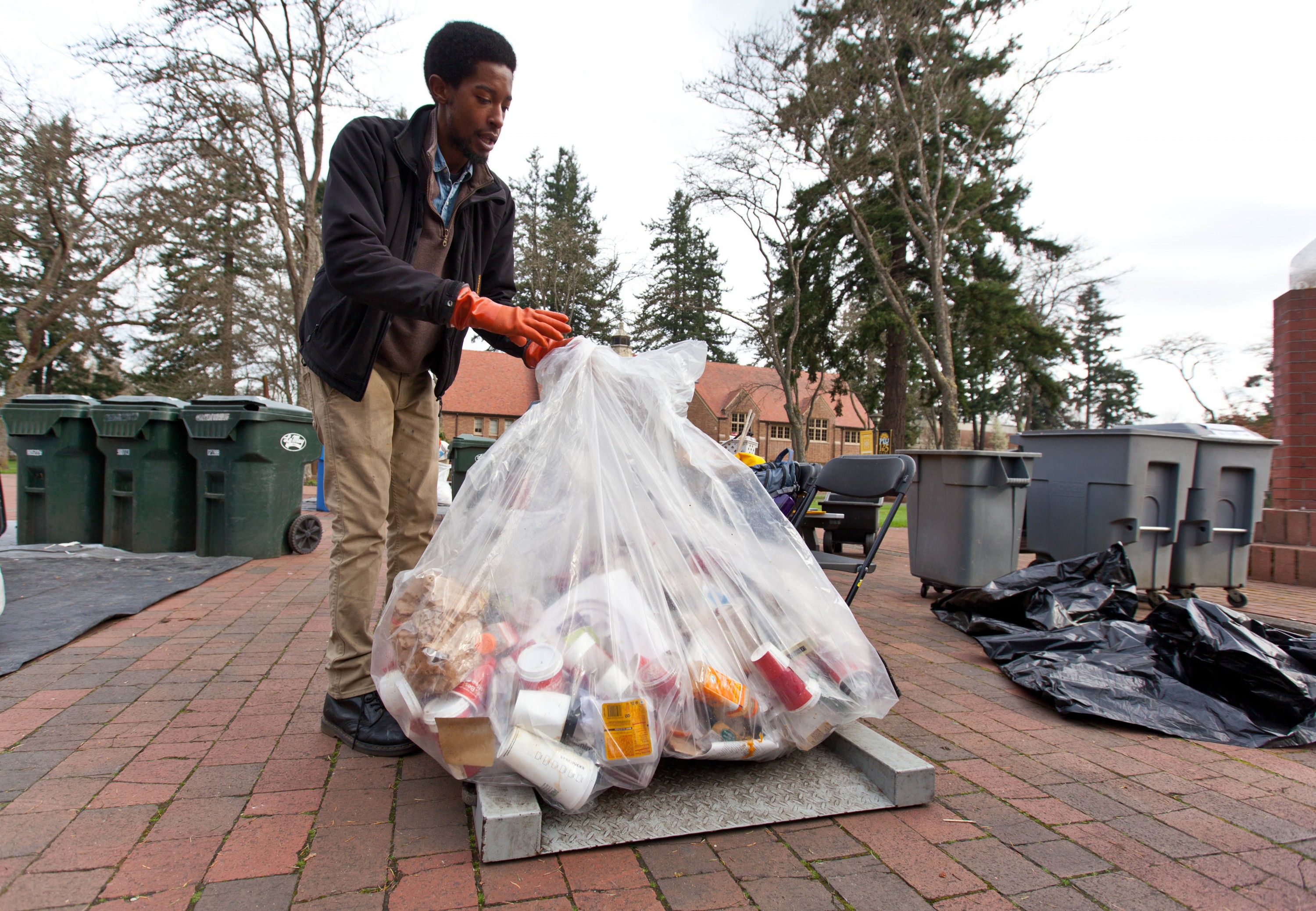 Ryan Grant weighs a bag of recyclables during Garbology on Red Square, where grash from different locations is sorted to determine how much is recycleable or compostable at PLU on Tuesday, March 17, 2015. (Photo: John Froschauer/PLU)