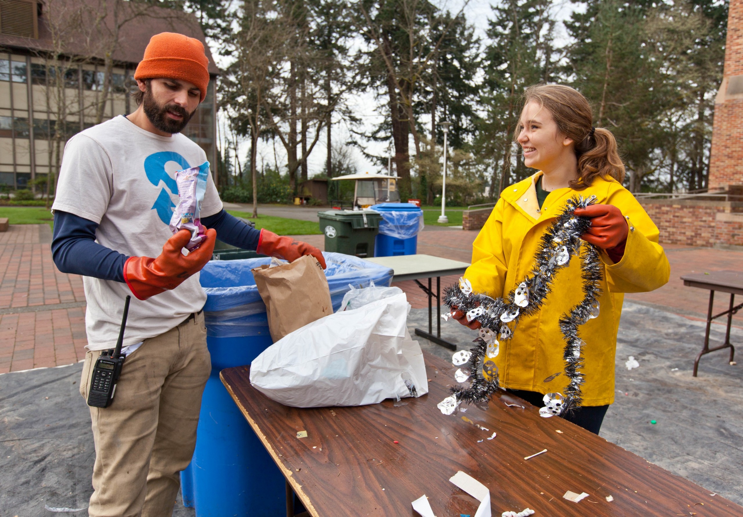 Nick Lorax and Savannah Phalan 15, compare their finds while working on a table of trash during Garbology on Red Square, where grash from different locations is sorted to determine how much is recycleable or compostable at PLU on Tuesday, March 17, 2015. (Photo: John Froschauer/PLU)