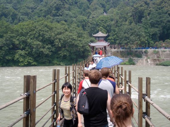 Wind Ensemble walking across a wooden bridge in China