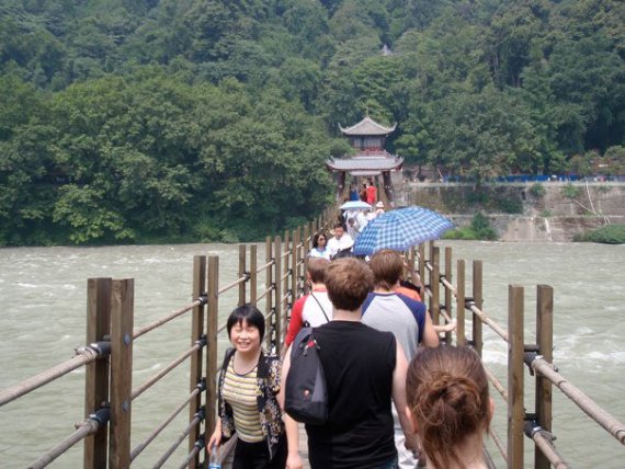 Bridge Wind Ensemble walking across a wooden bridge in China