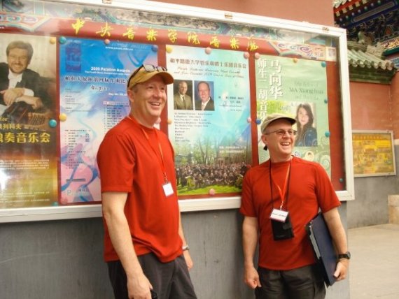 Ed Powell and David Deacon-Joyner standing by their poster in China