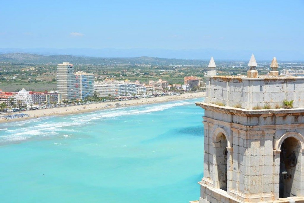 2017 Spain and Portugal University Wind Ensemble Trip - A panoramic view of a vibrant city situated by the water's edge, featuring modern buildings and a tall tower.