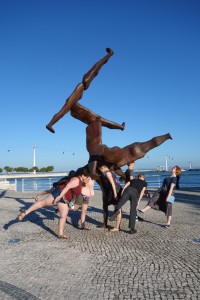 2017 Spain and Portugal University Wind Ensemble Trip - A group of people pose with a statue near the waterfront.