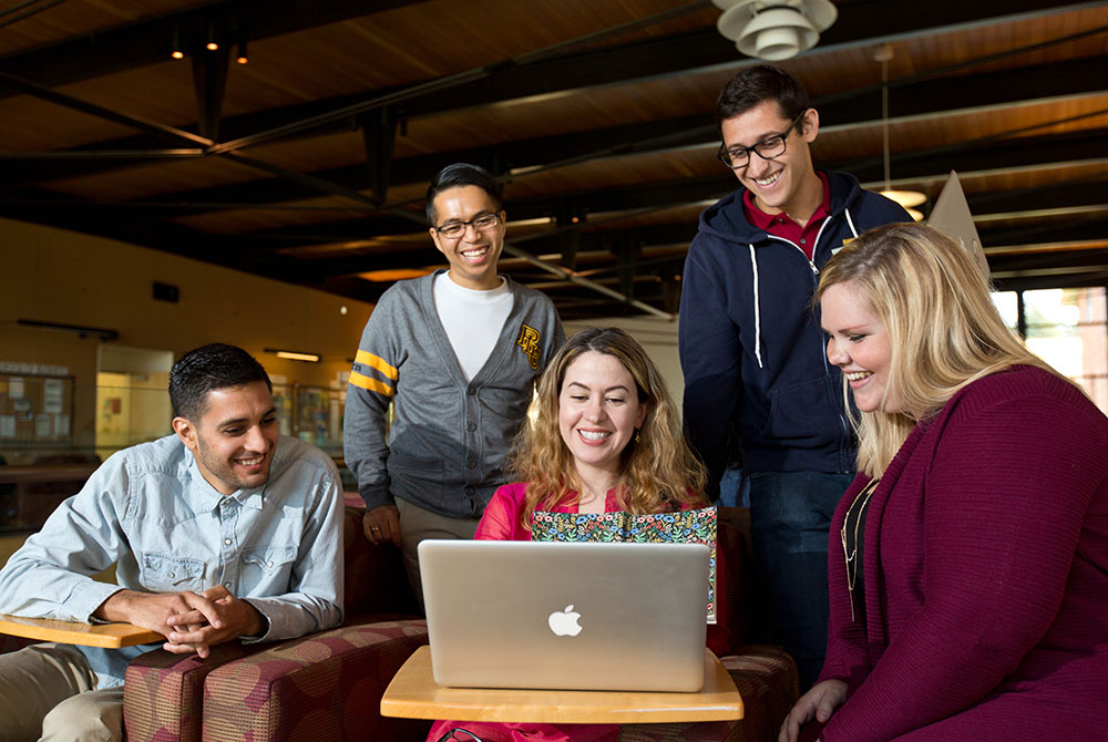 MSMR students at PLU smiling while working on a computer