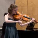 Alyson Rake playing a stringed instrument.
